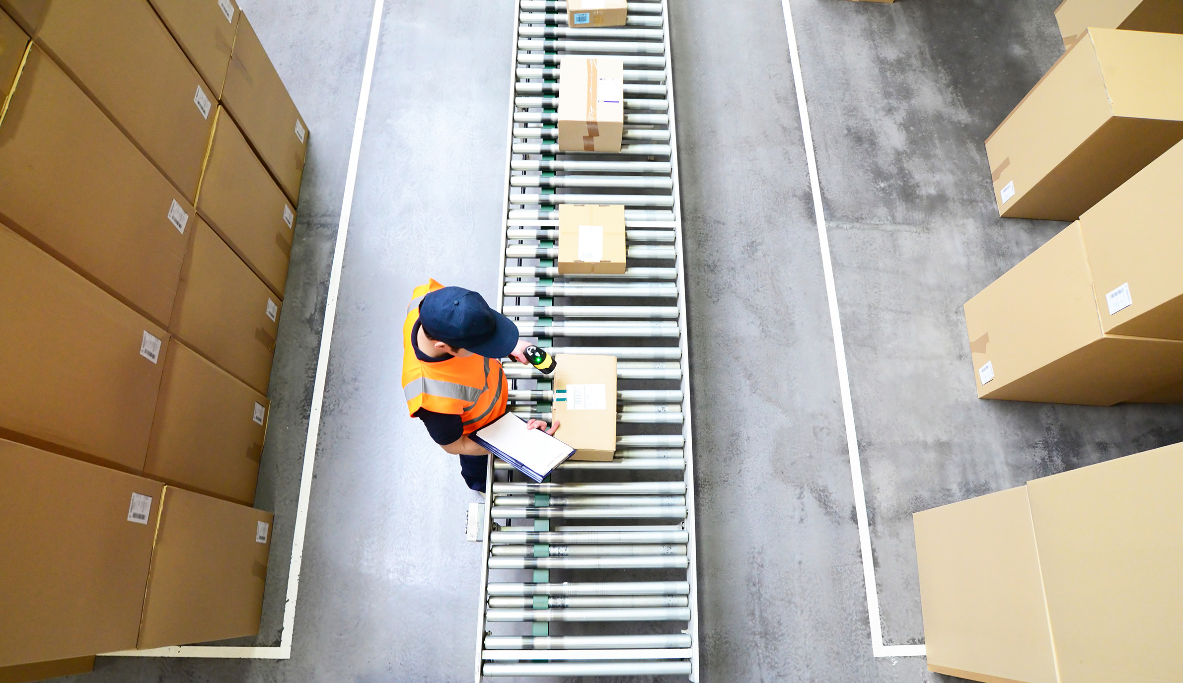 Workers in a mail order company scan packages for shipping // Ar